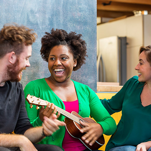 Afrikanische Frau mit Gitarre und zwei Freunden